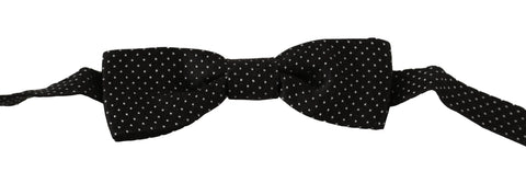 Black silk bow tie with white polka dots, adjustable neck strap, by Dolce & Gabbana, designed for men's formal wear.