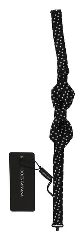 Black silk bow tie with white polka dots, adjustable neck strap, men's accessory by Dolce & Gabbana.