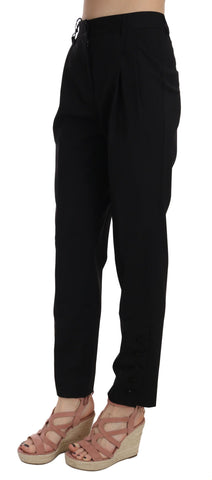 Black button-pleated tapered trouser pants by Dolce & Gabbana with tailored fit and classic design, shown hanging on a wooden hanger.