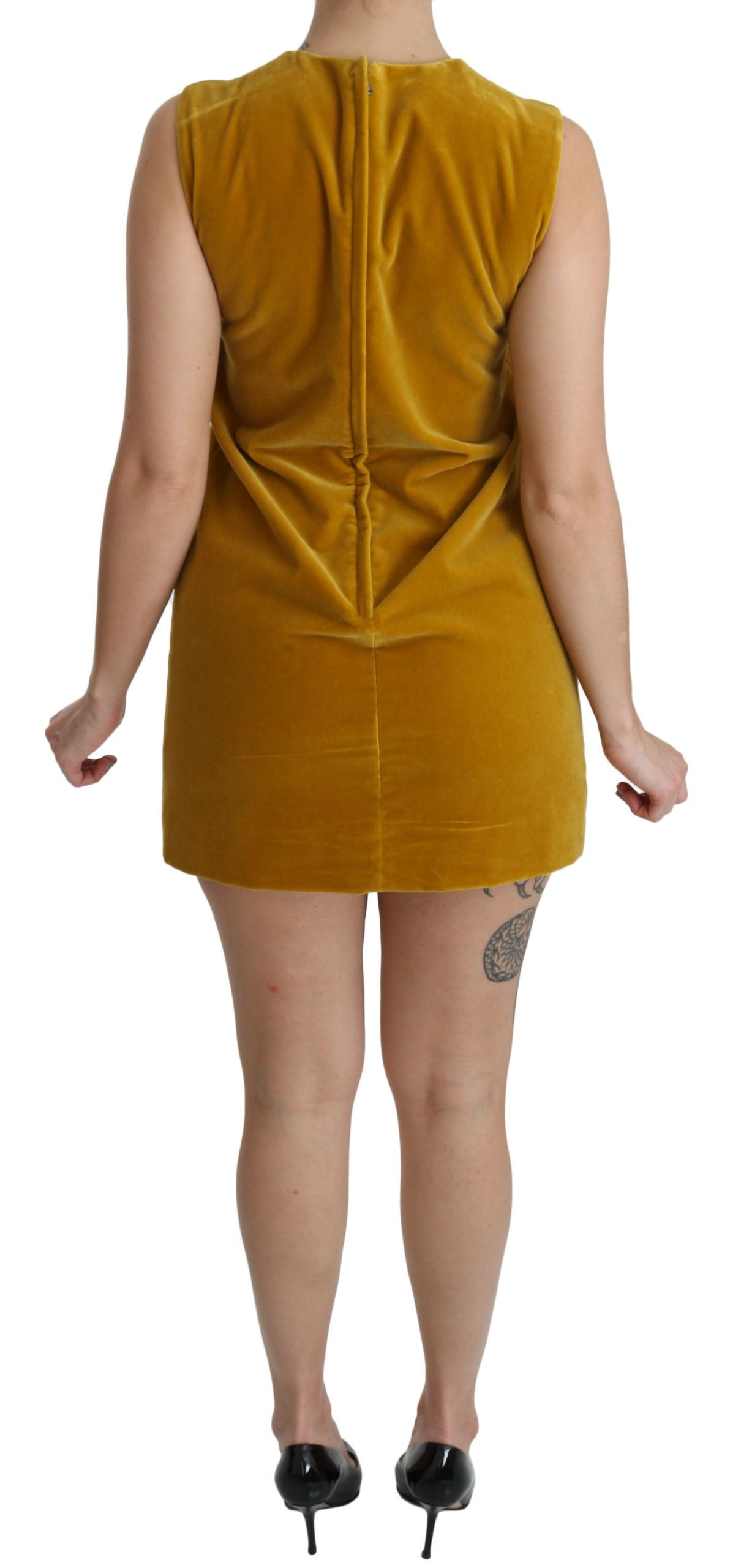 Dolce & Gabbana mustard velvet stretch shift mini dress hanging on a clothing rack, showcasing its elegant fabric and fit.