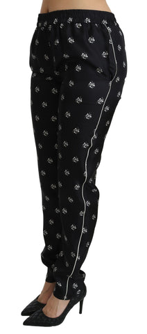 Black printed silk skinny pants with mid waist fit by Dolce & Gabbana, shown with a close-up of the fabric and design details.