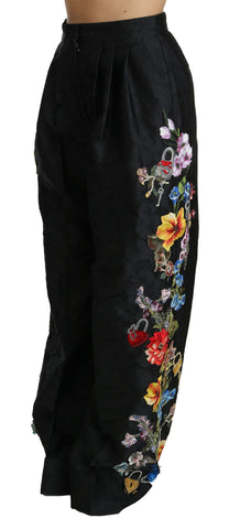 Black brocade floral sequined beaded pants by Dolce & Gabbana featuring intricate embroidery and shimmering embellishments.