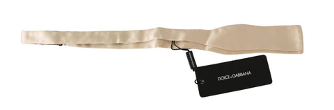 Beige slim skinny men's silk necktie or bowtie by Dolce & Gabbana, featuring a smooth, elegant texture and classic style.