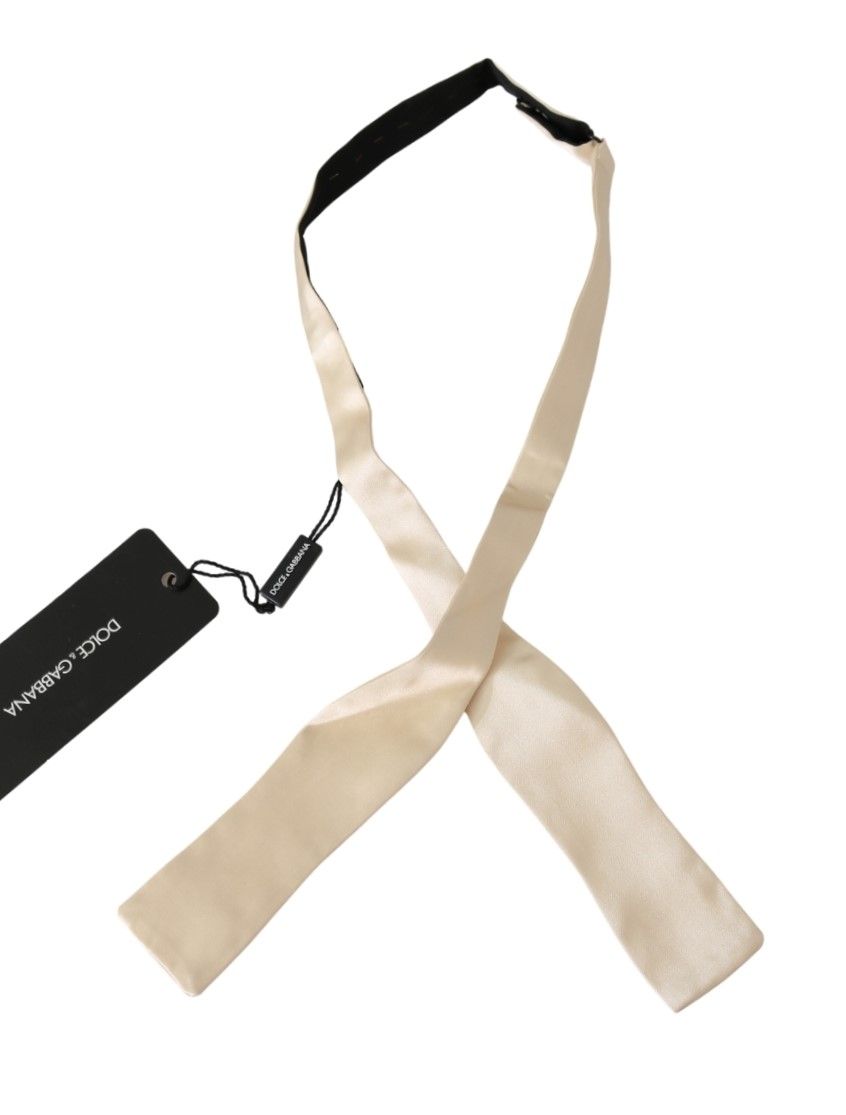 Beige slim skinny men's silk bowtie by Dolce & Gabbana, featuring a sleek and elegant design for formal wear.