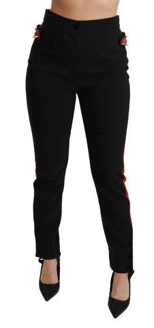 Black skinny stretch cotton pants with fox head print from Dolce & Gabbana, close-up view showing fit and fabric texture.