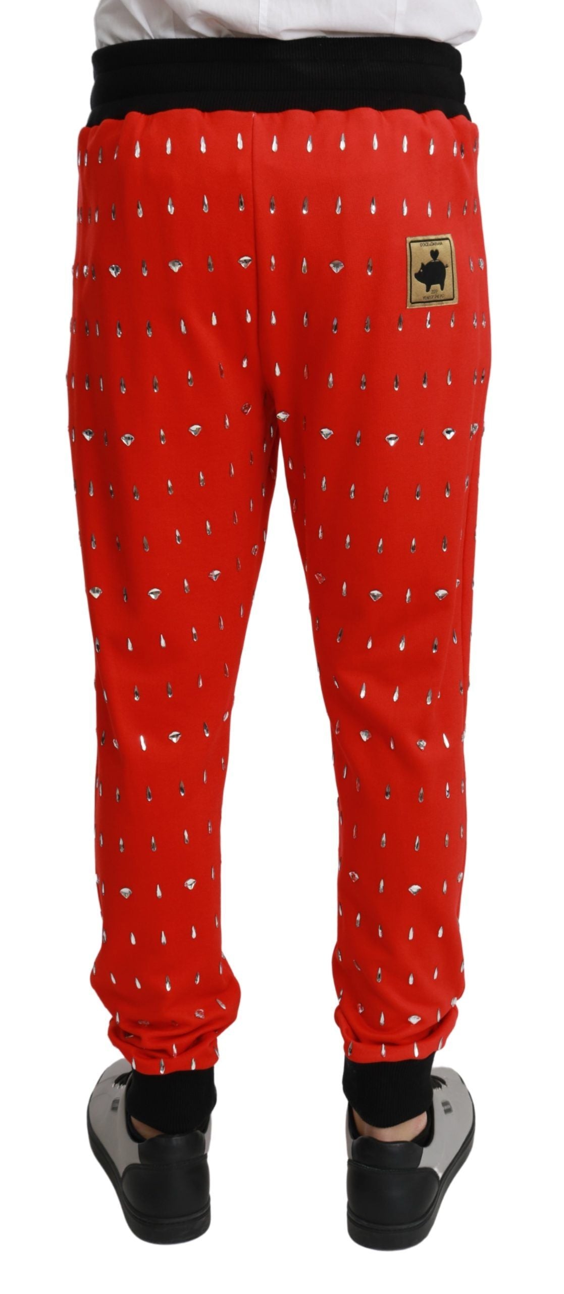 Red piggy bank-shaped cotton trousers by Dolce & Gabbana, featuring a playful piggy bank motif and tailored fit.