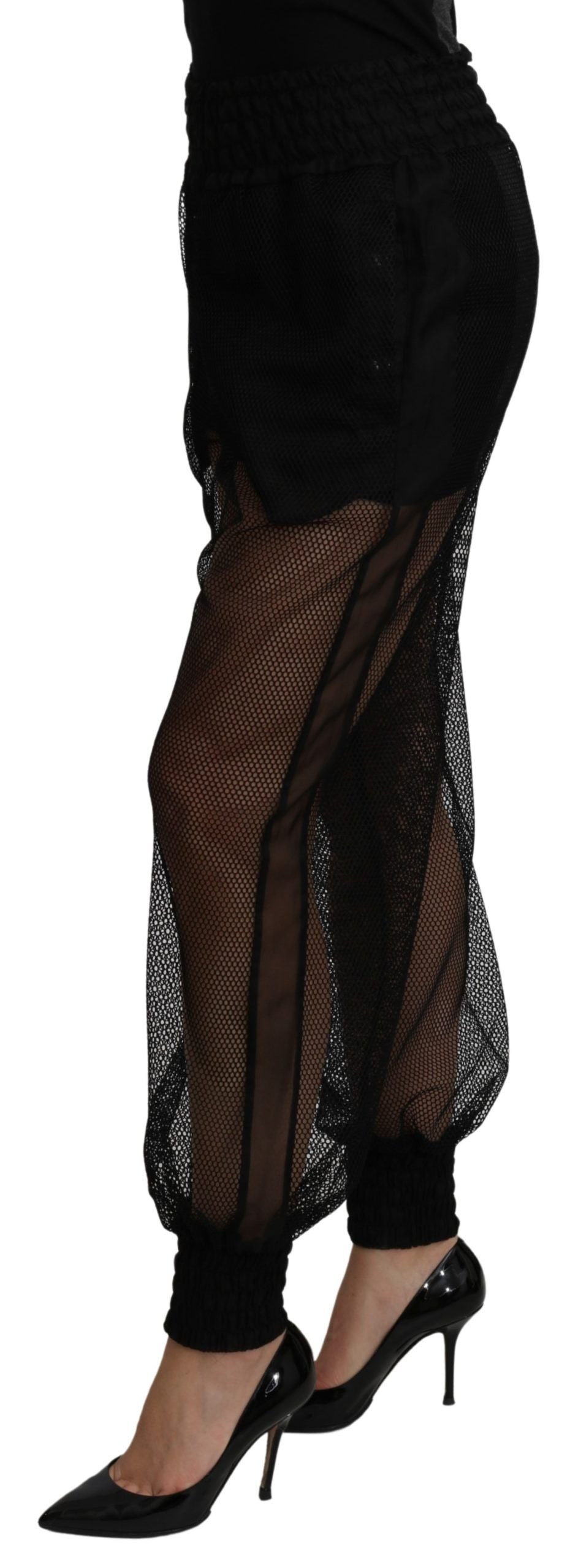 Black see-through polyester jogger pants by Dolce & Gabbana featuring a relaxed fit and transparent fabric design.