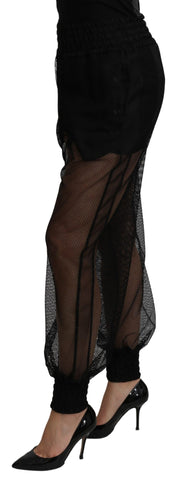 Black see-through polyester jogger pants by Dolce & Gabbana featuring a relaxed fit and transparent fabric design.