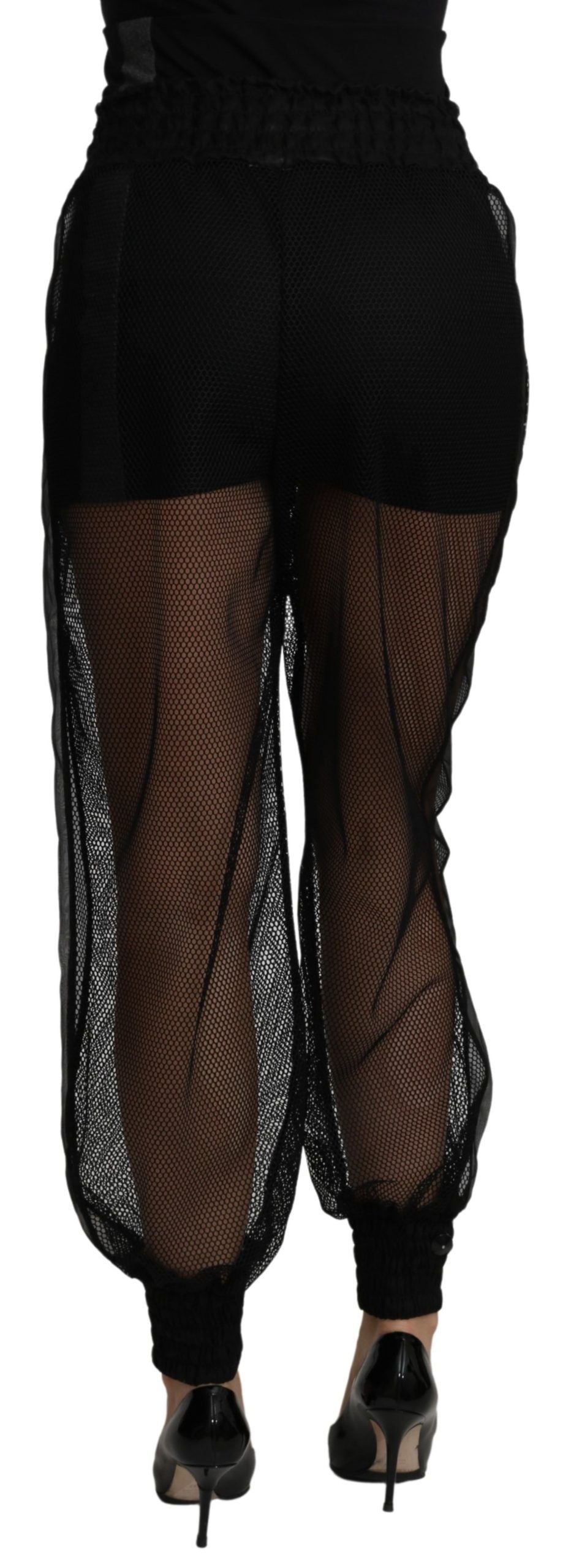 Black see-through polyester jogger pants by Dolce & Gabbana, featuring a transparent design and relaxed fit.