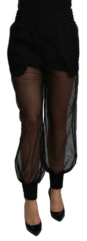 Black see-through polyester jogger pants by Dolce & Gabbana, featuring a relaxed fit and transparent fabric detail.
