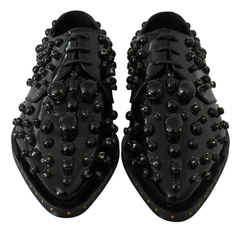 Black leather brogue shoes with crystal embellishments from Dolce & Gabbana, featuring detailed stitching and classic wingtip design.