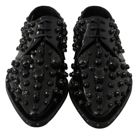 Black leather brogue shoes with crystal accents from Dolce & Gabbana, featuring a classic lace-up design and polished finish.