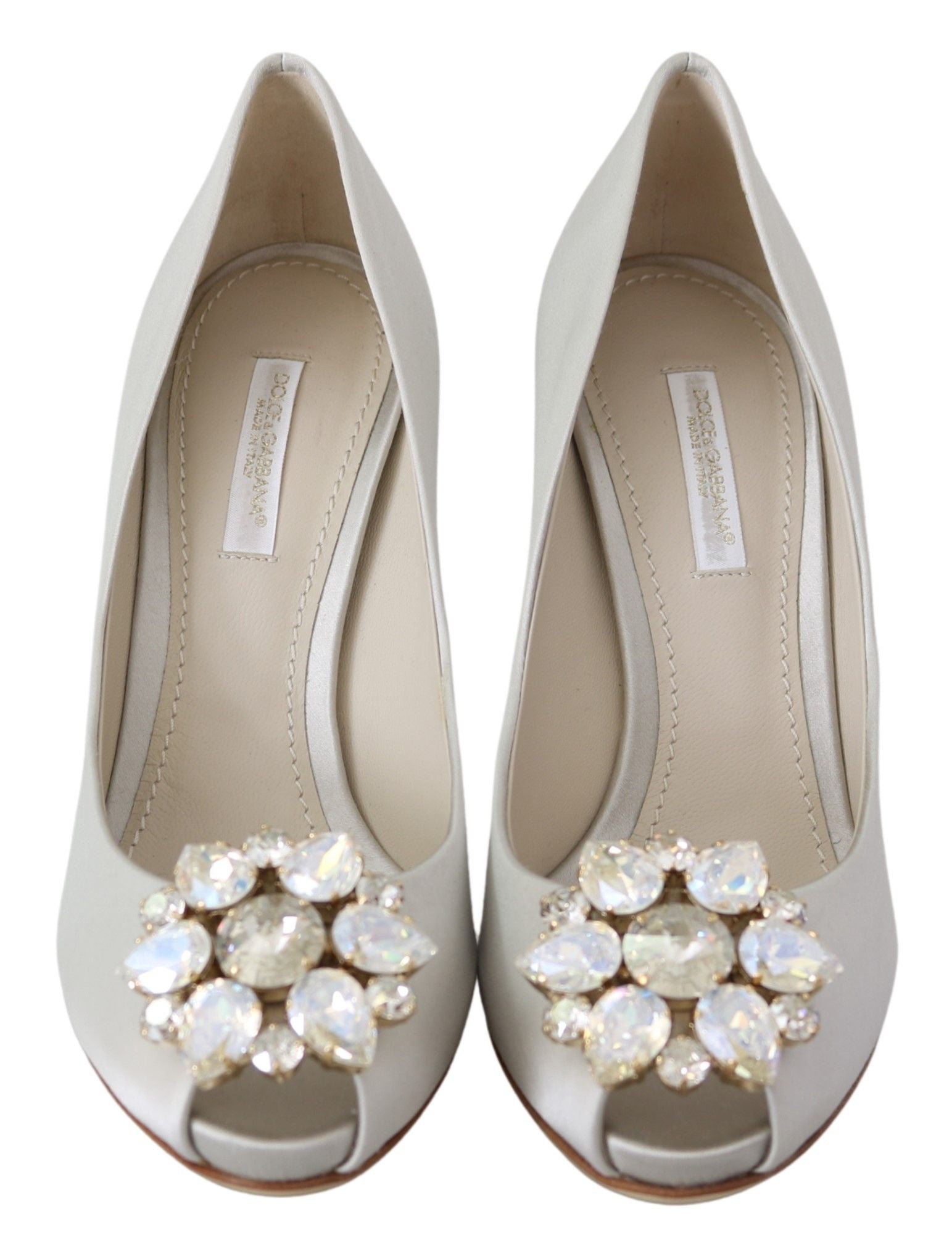 White satin Dolce & Gabbana peep toe heels with crystal embellishments and elegant design.