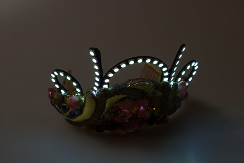Gold brass floral crown with crystals, LED lights, tiara, and diadem design by Dolce & Gabbana, featuring intricate floral detailing.