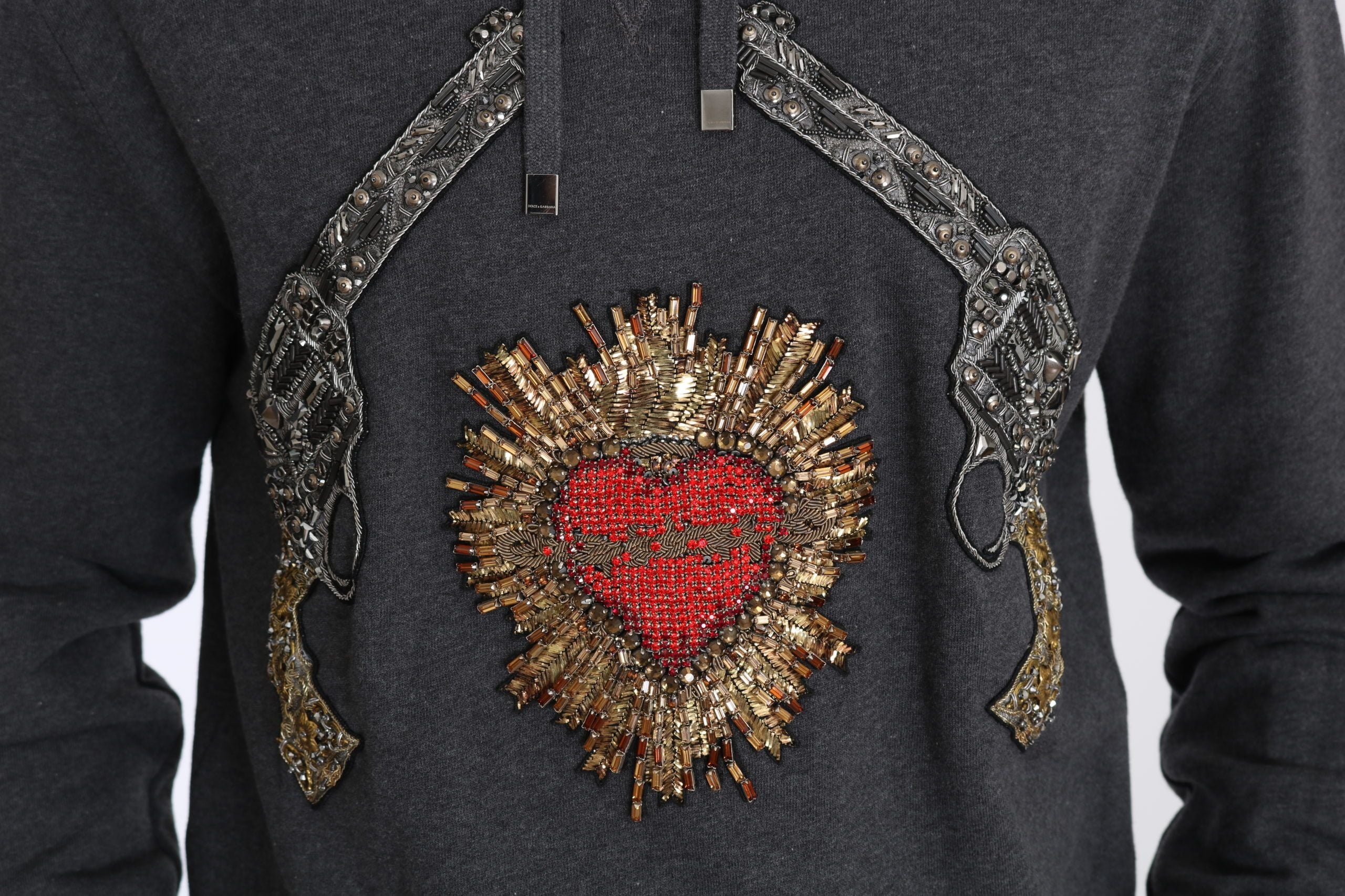 Gray hooded sweater with red crystal heart and gun graphic by Dolce & Gabbana, featuring a casual, stylish design.