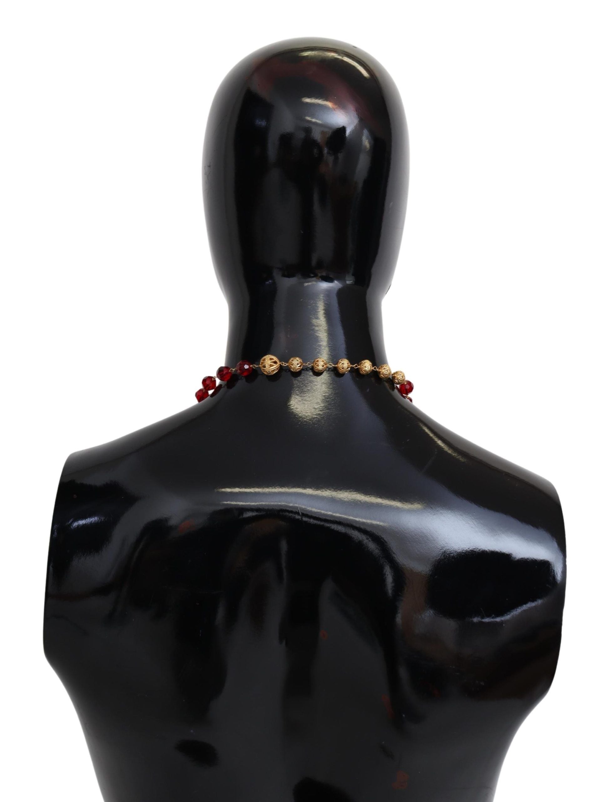 Gold tone brass necklace with red crystal pendant on opera chain, Dolce & Gabbana jewelry piece.