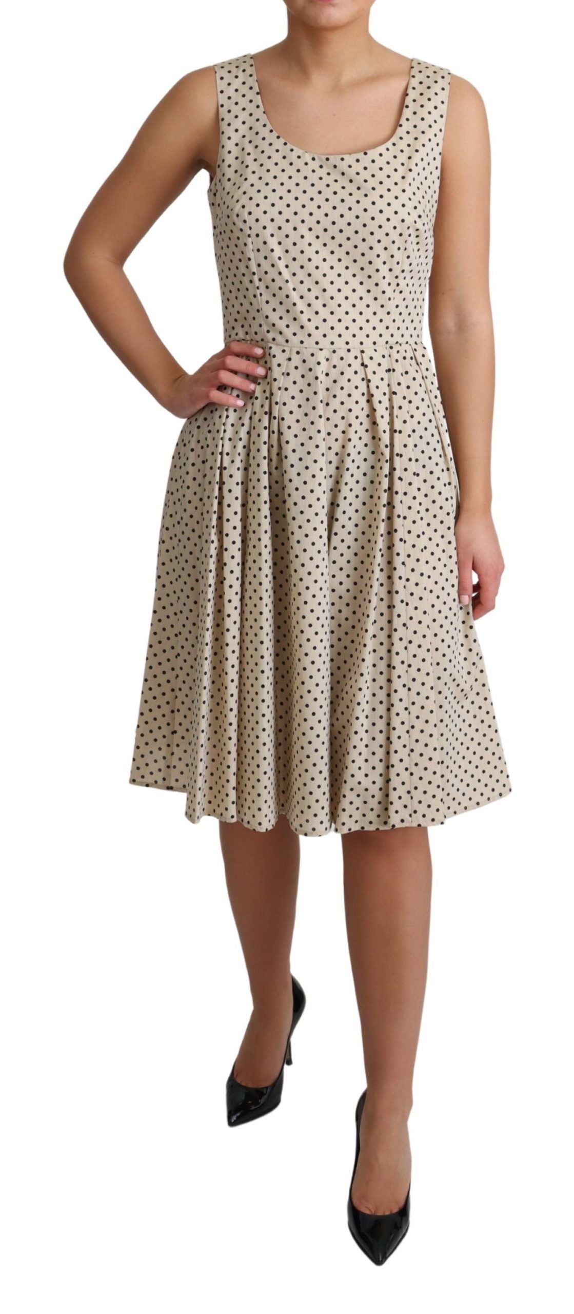 Beige polka dotted cotton A-line dress by Dolce & Gabbana hanging on a wooden hanger.