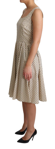 Beige polka dotted cotton A-line dress by Dolce & Gabbana, featuring a fitted bodice and flowing skirt.