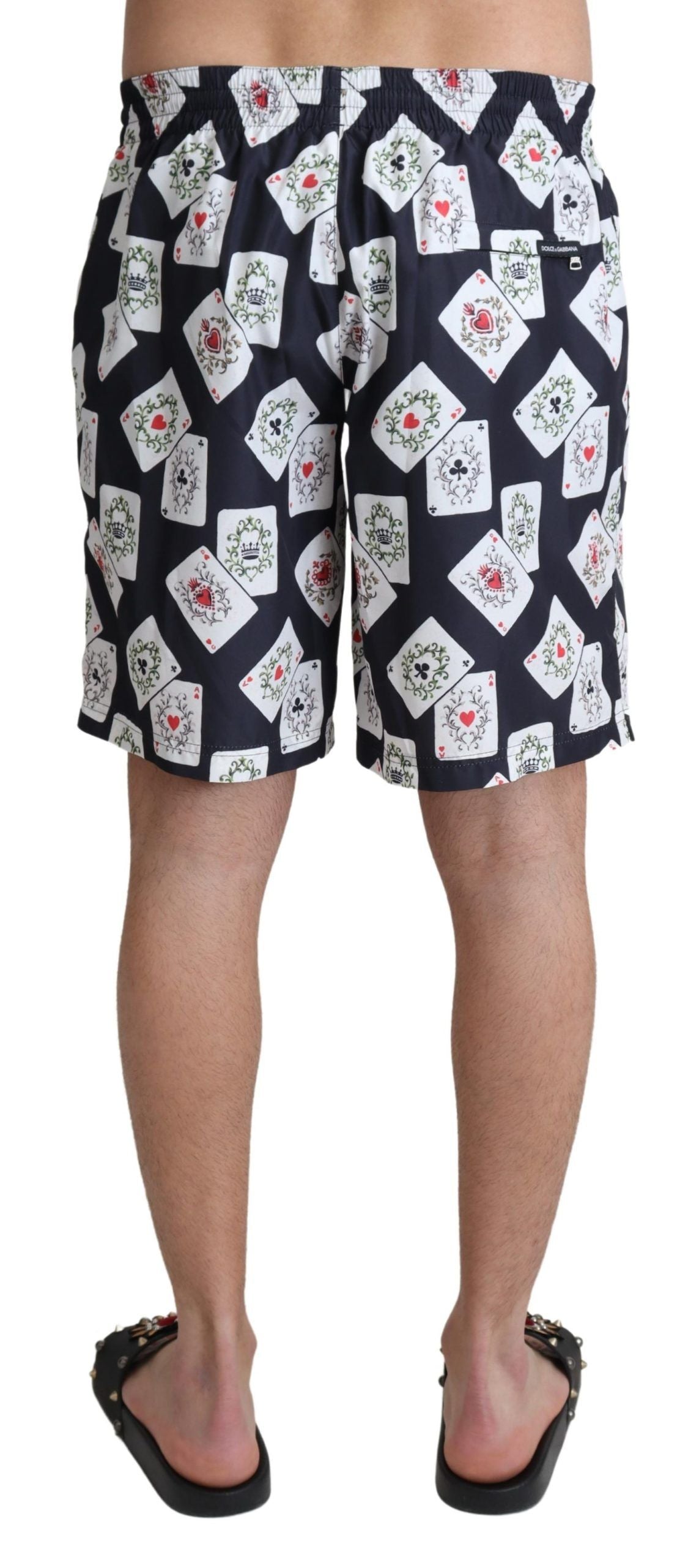 Black card deck print Dolce & Gabbana beachwear swimshorts with a stylish design, shown laid flat on a neutral background.