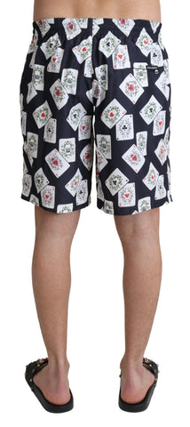 Black card deck print Dolce & Gabbana beachwear swimshorts with a stylish design, shown laid flat on a neutral background.