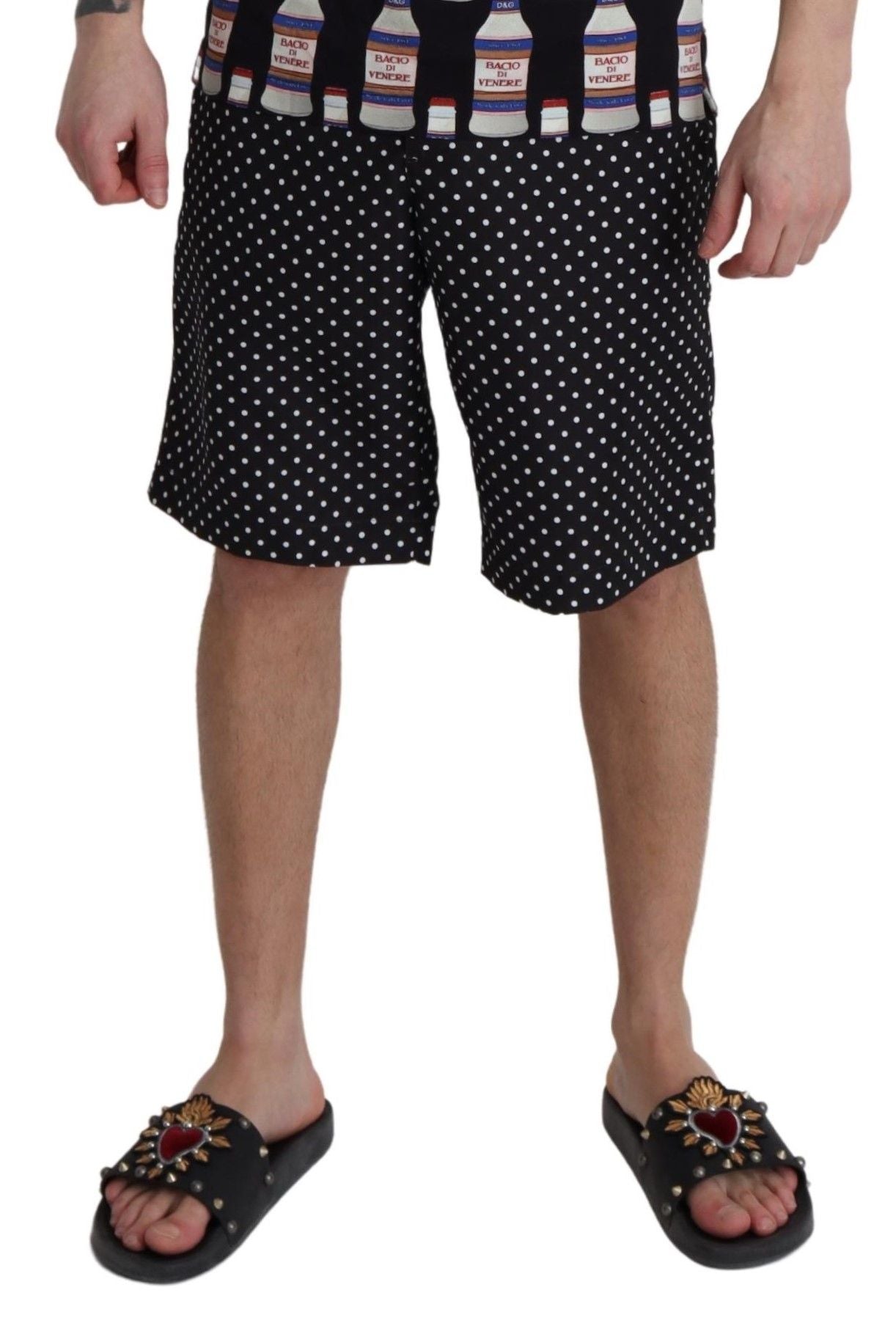 Black polka dots Dolce & Gabbana beachwear shorts swimwear shown on a model with a relaxed beach setting.