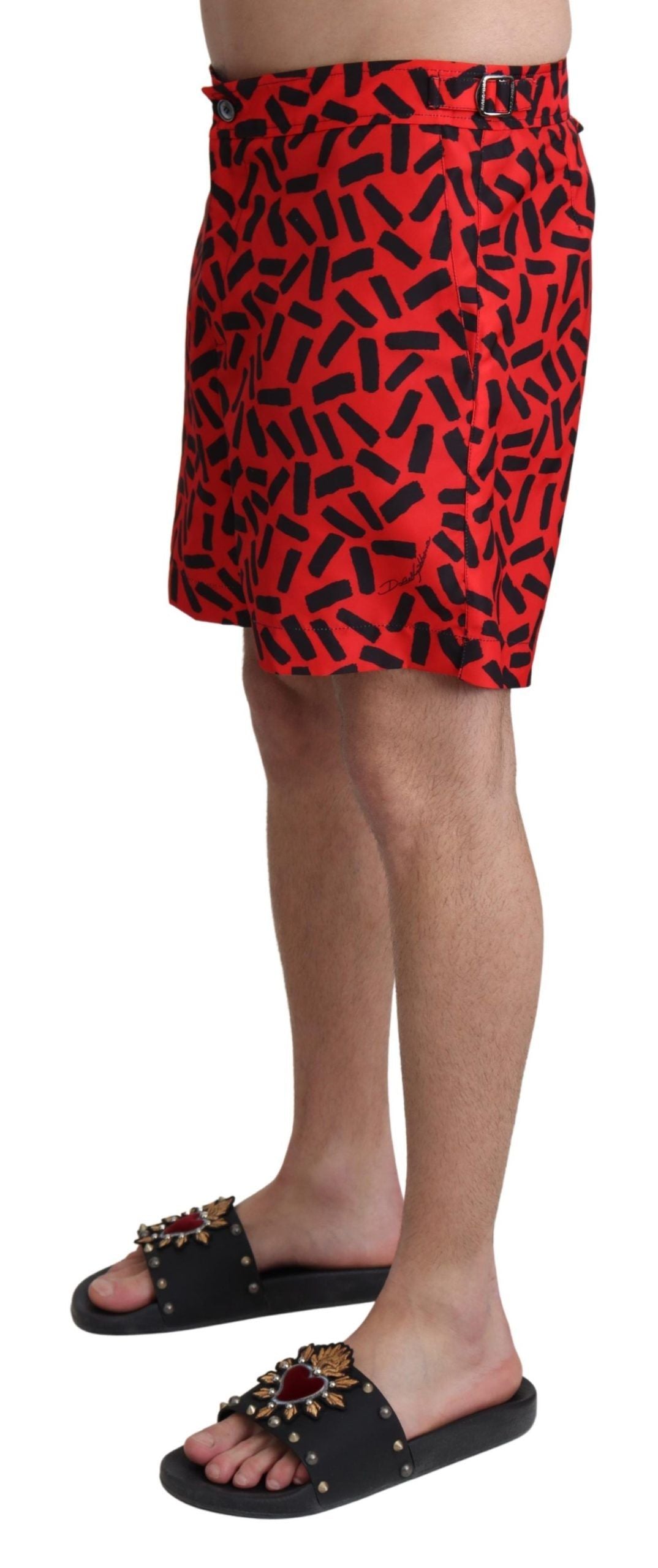 Red patterned Dolce & Gabbana beachwear shorts with a stylish swimwear design, featuring vibrant tropical print and comfortable fit.