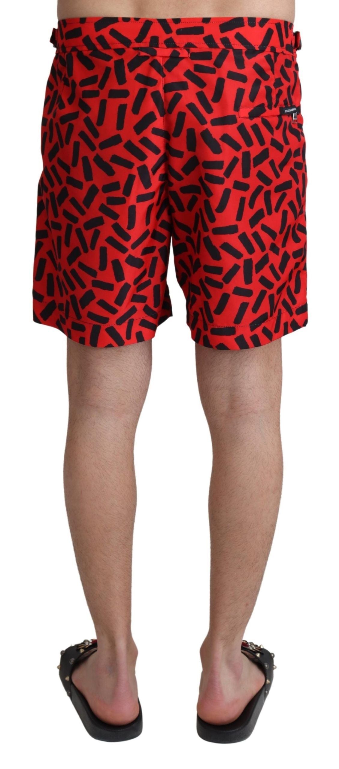 Red patterned Dolce & Gabbana beachwear shorts with a stylish swimwear design, featuring a vibrant, eye-catching pattern.