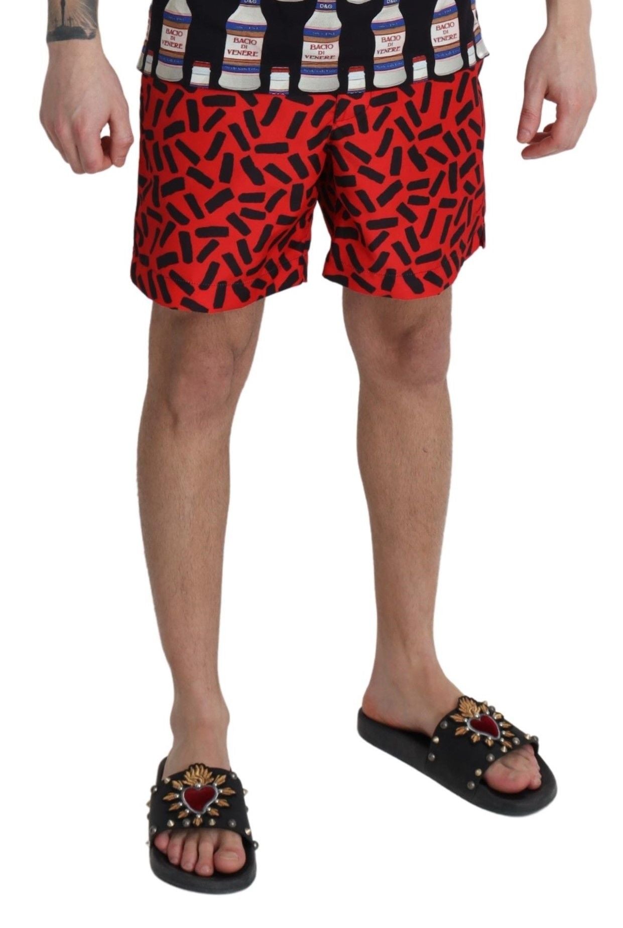 Red patterned Dolce & Gabbana beachwear shorts with floral design, suitable for swimwear or beach outings.