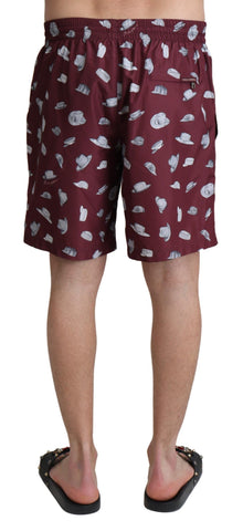 Maroon Dolce & Gabbana beachwear shorts with hat print, stylish swimwear for men, featuring vibrant design and comfortable fit.