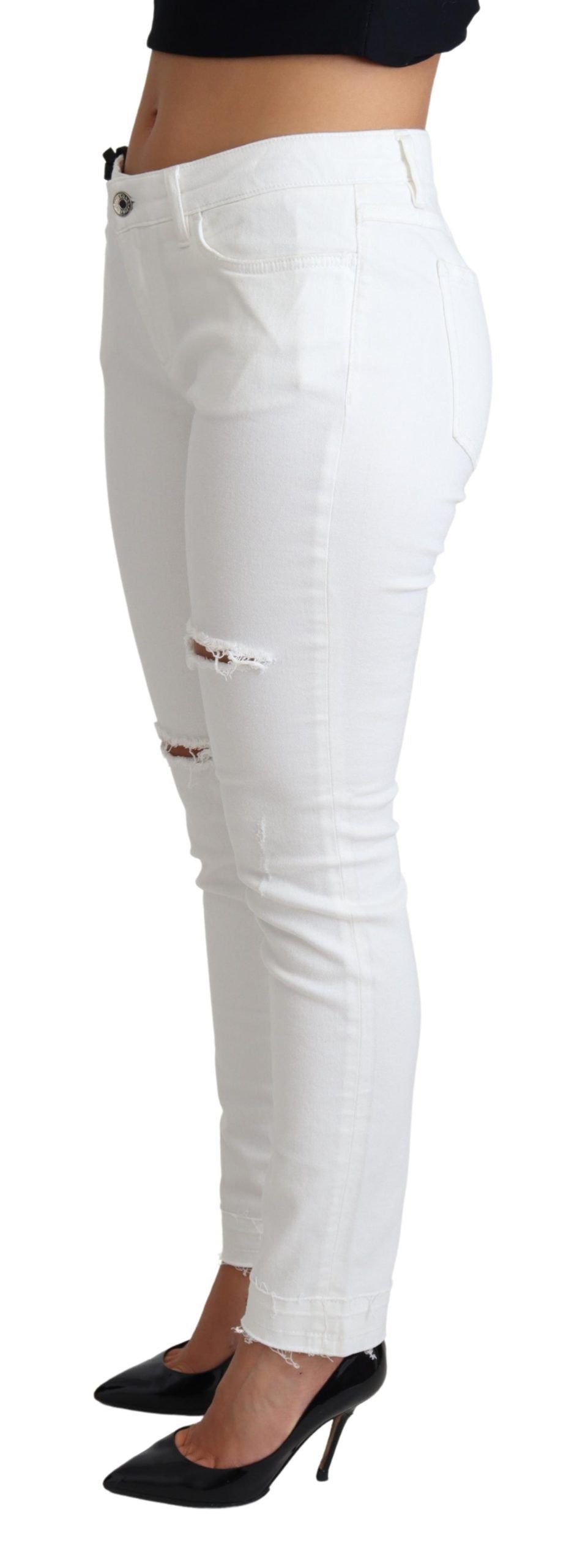 White tattered skinny denim jeans by Dolce & Gabbana, showing distressed cotton stretch fabric and fitted silhouette.