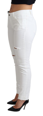 White tattered skinny denim jeans by Dolce & Gabbana, showing distressed cotton stretch fabric and fitted silhouette.