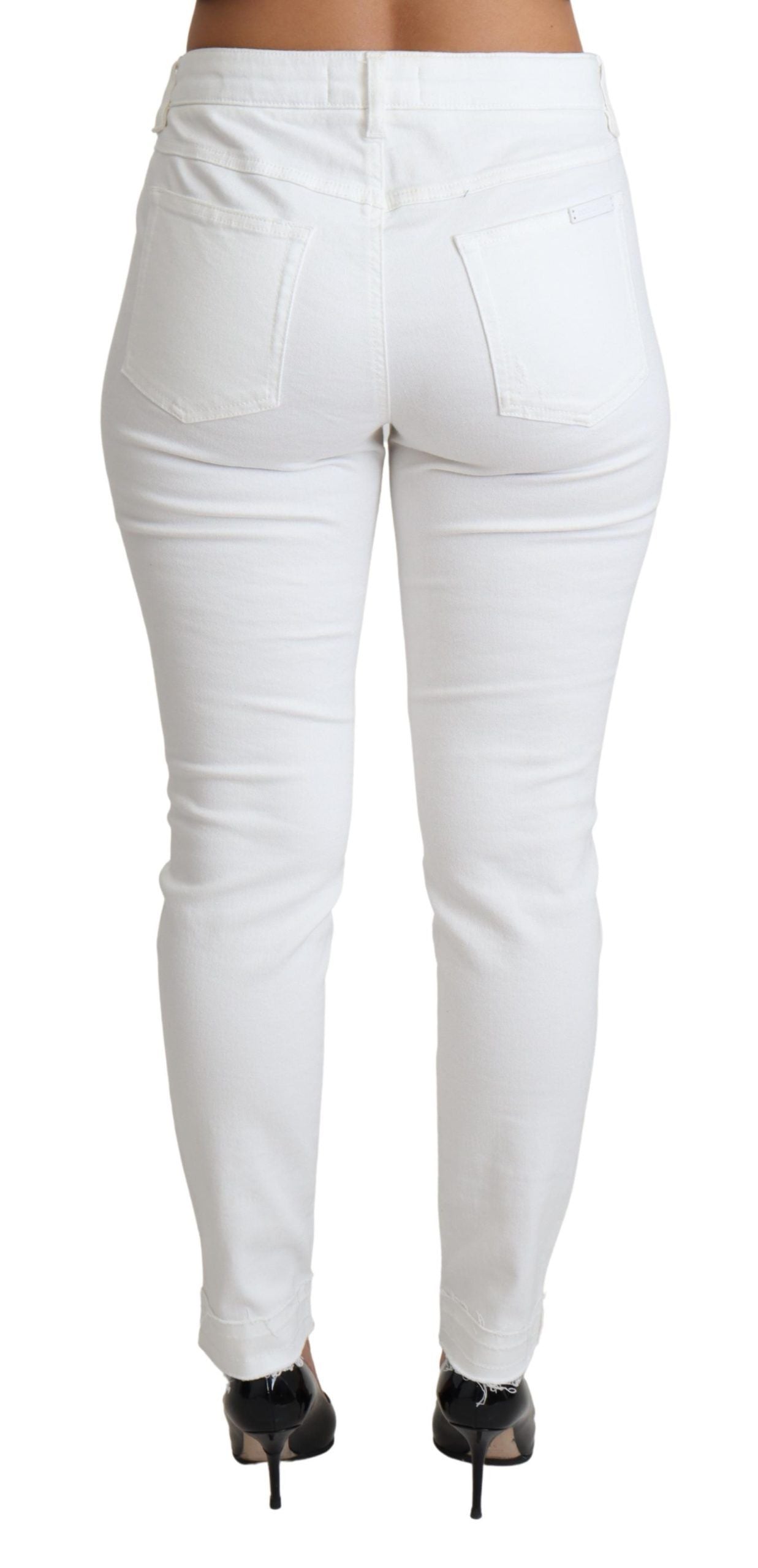 White tattered skinny denim jeans by Dolce & Gabbana, showing distressed cotton stretch fabric and slim fit design.