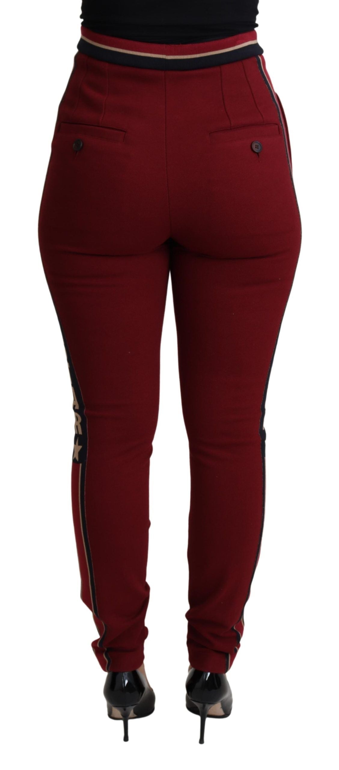 Red Dolce & Gabbana DG Star striped skinny cotton pants shown on a model, featuring bold star pattern and slim fit design.