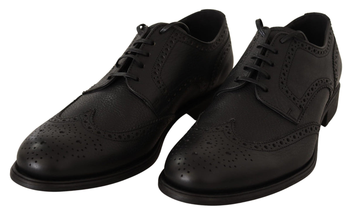 Black leather Oxford wingtip dress shoes by Dolce & Gabbana with brogue detailing and polished finish.