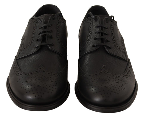 Dolce & Gabbana black leather Oxford wingtip formal dress shoes, detailed broguing and sleek design, on a plain background.