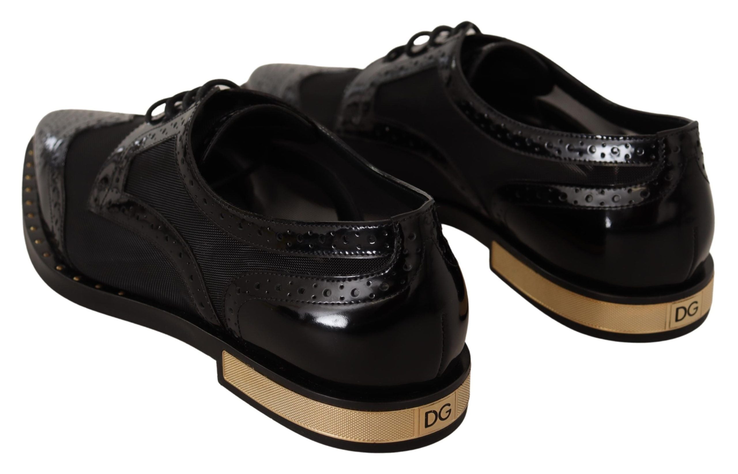 Black leather brogue wingtip shoes by Dolce & Gabbana with sheer detailing, classic wingtip design, and polished finish.