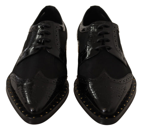 Black leather brogue wingtip shoes by Dolce & Gabbana featuring sheer panels and classic wingtip detailing.