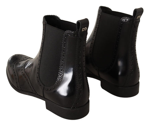 Black leather ankle-high flat boots by Dolce & Gabbana with sleek design and rounded toes.