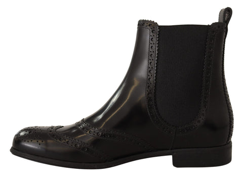Black leather ankle-high flat boots by Dolce & Gabbana with sleek design and rounded toe, perfect for casual or chic outfits.