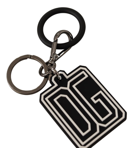 Black and white Dolce & Gabbana rubber logo silver ring keychain with engraved branding and sleek design.