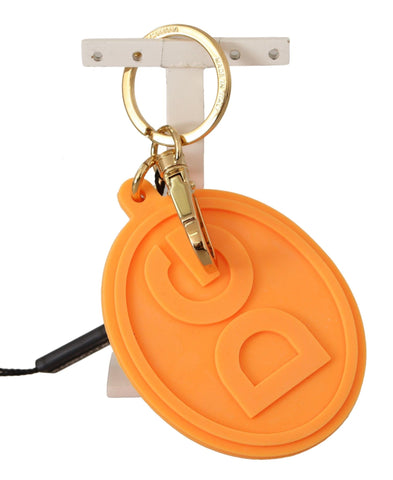 Orange rubber Dolce & Gabbana keychain with gold brass DG logo and metal ring attachment.