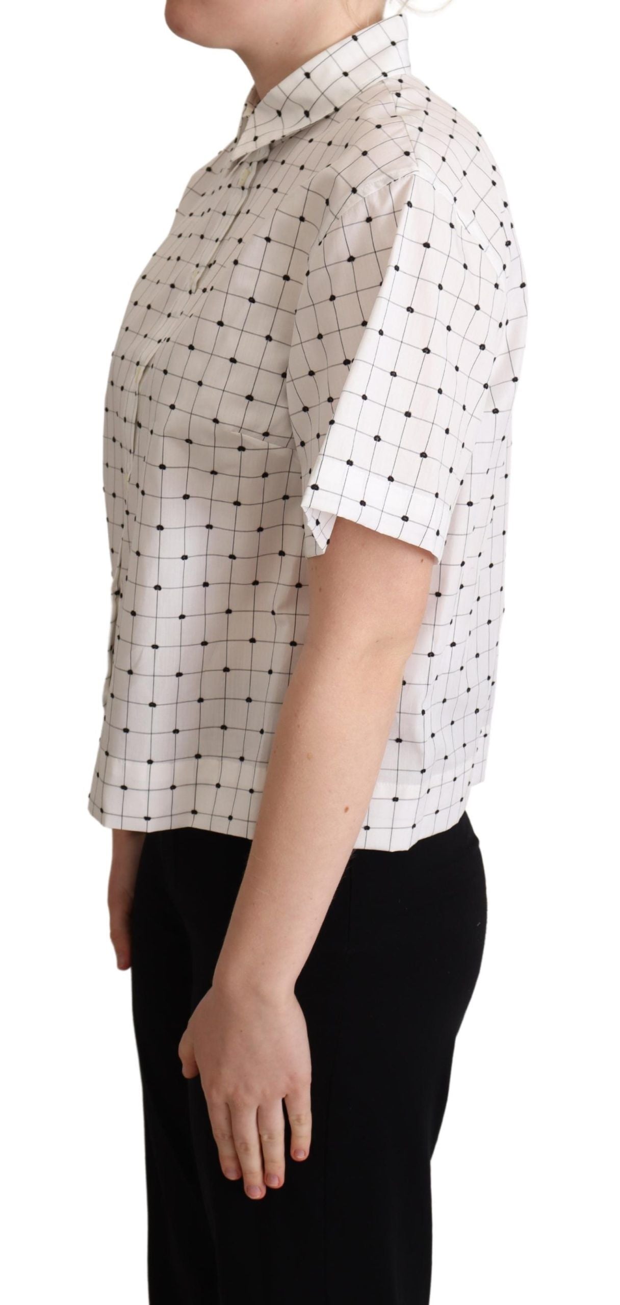 White cotton collared shirt top with black polka dots by Dolce & Gabbana, shown on a hanger.