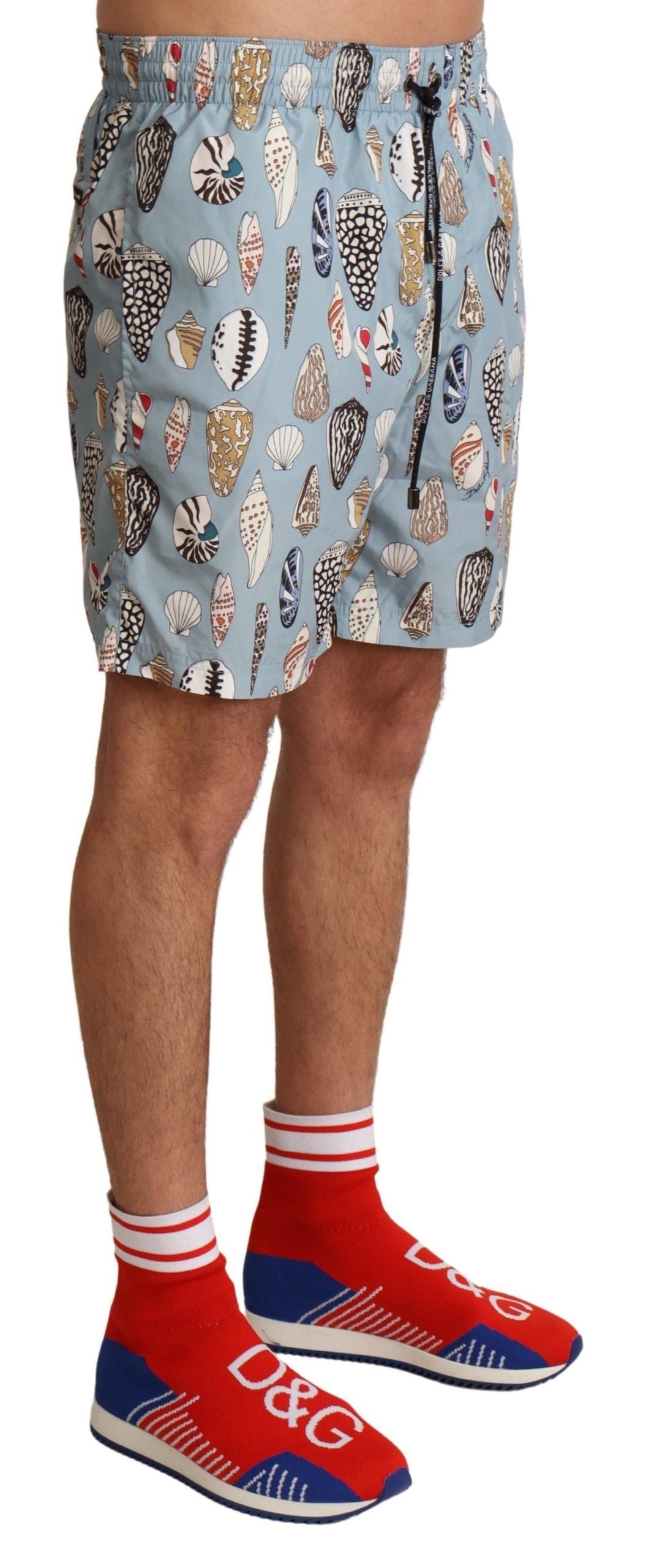 Blue seashell patterned Dolce & Gabbana swimwear shorts for beachwear, featuring a stylish and comfortable fit.