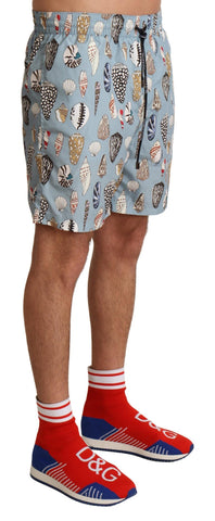 Blue seashell patterned Dolce & Gabbana swimwear shorts for beachwear, featuring a stylish and comfortable fit.