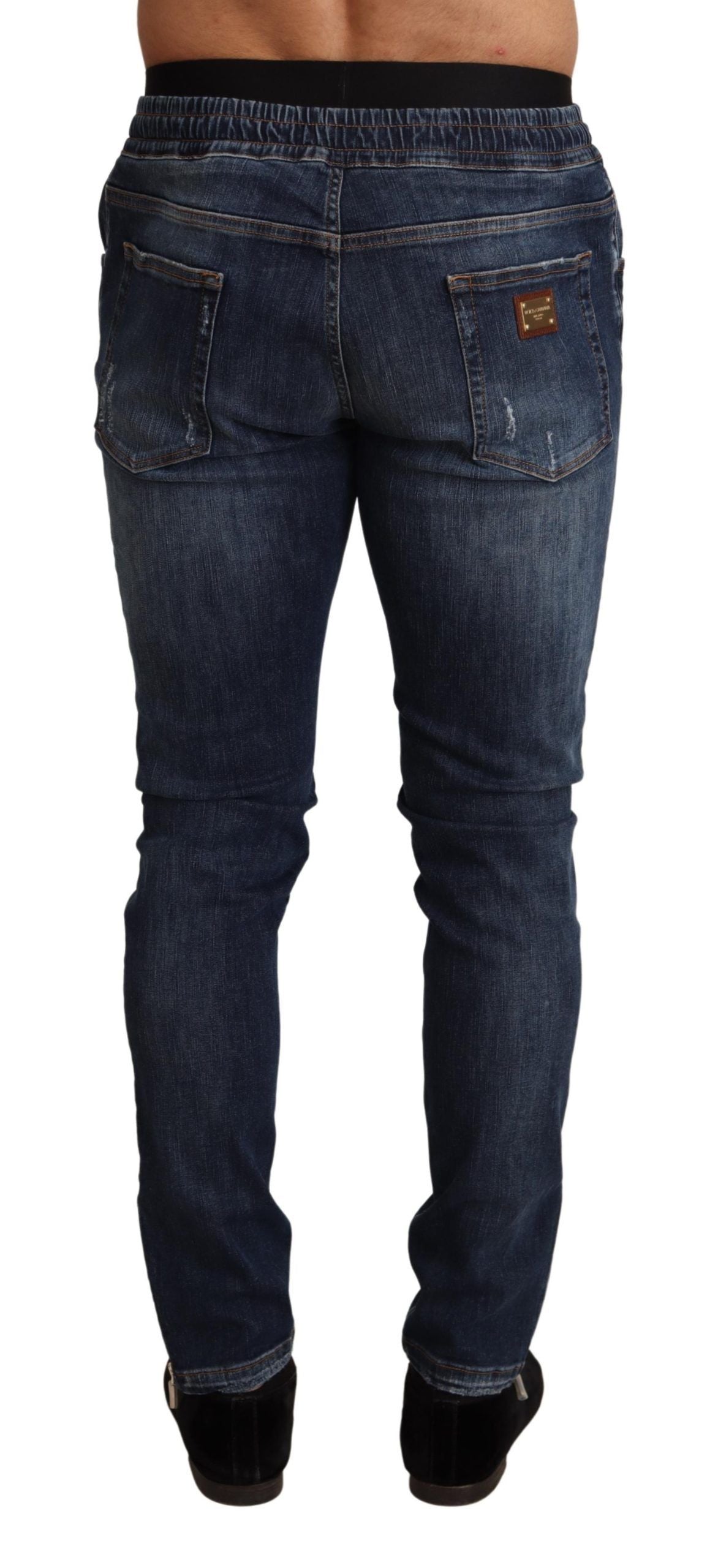 Blue cotton stretch tattered denim jeans by Dolce & Gabbana displayed on a hanger.