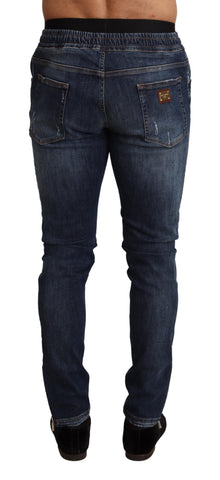 Blue cotton stretch tattered denim jeans by Dolce & Gabbana displayed on a hanger.