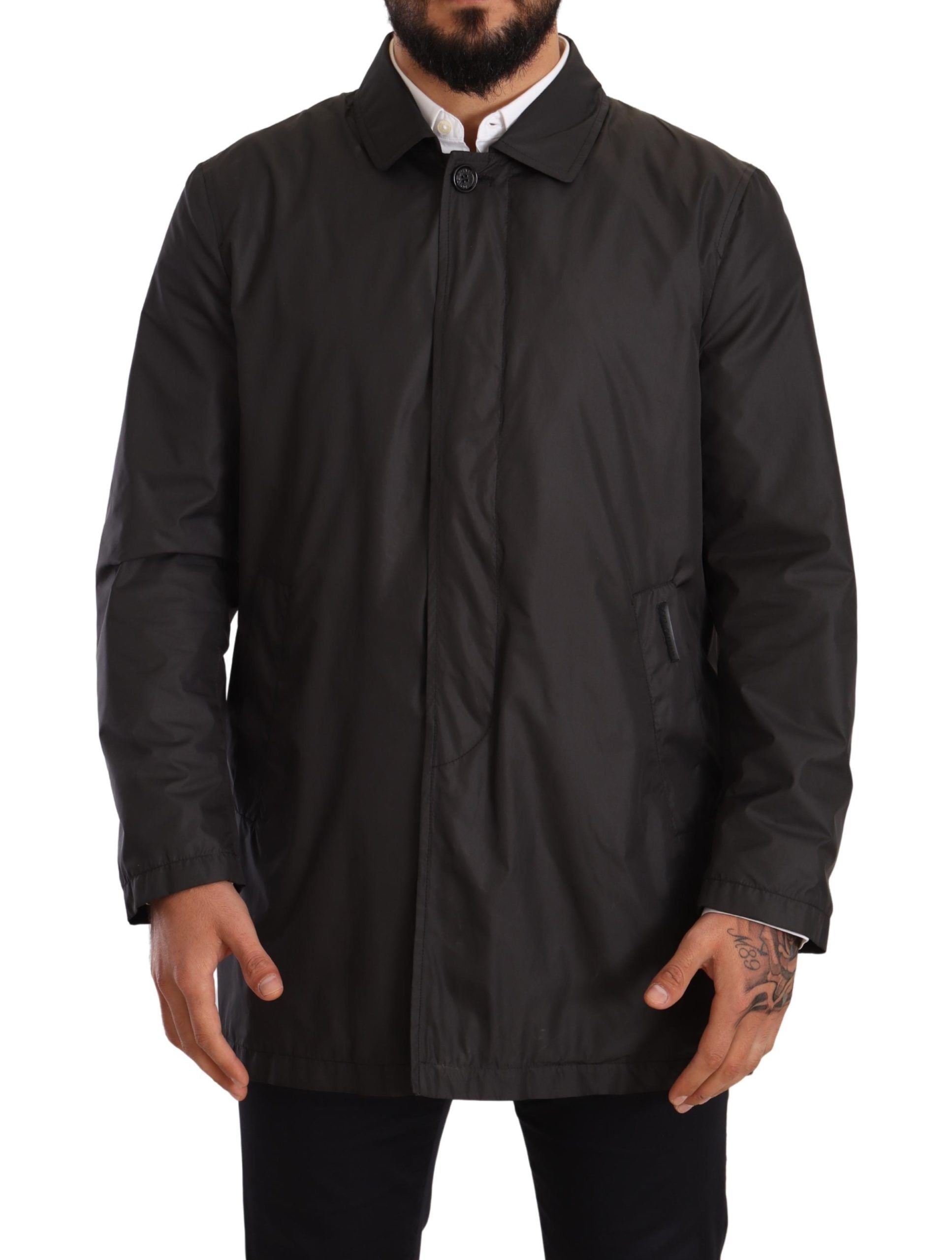 Black polyester men's trench coat jacket by Dolce & Gabbana, shown hanging with classic collar and button details.
