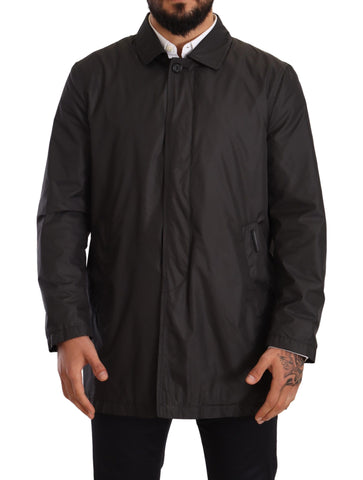 Black polyester men's trench coat jacket by Dolce & Gabbana, shown hanging with classic collar and button details.