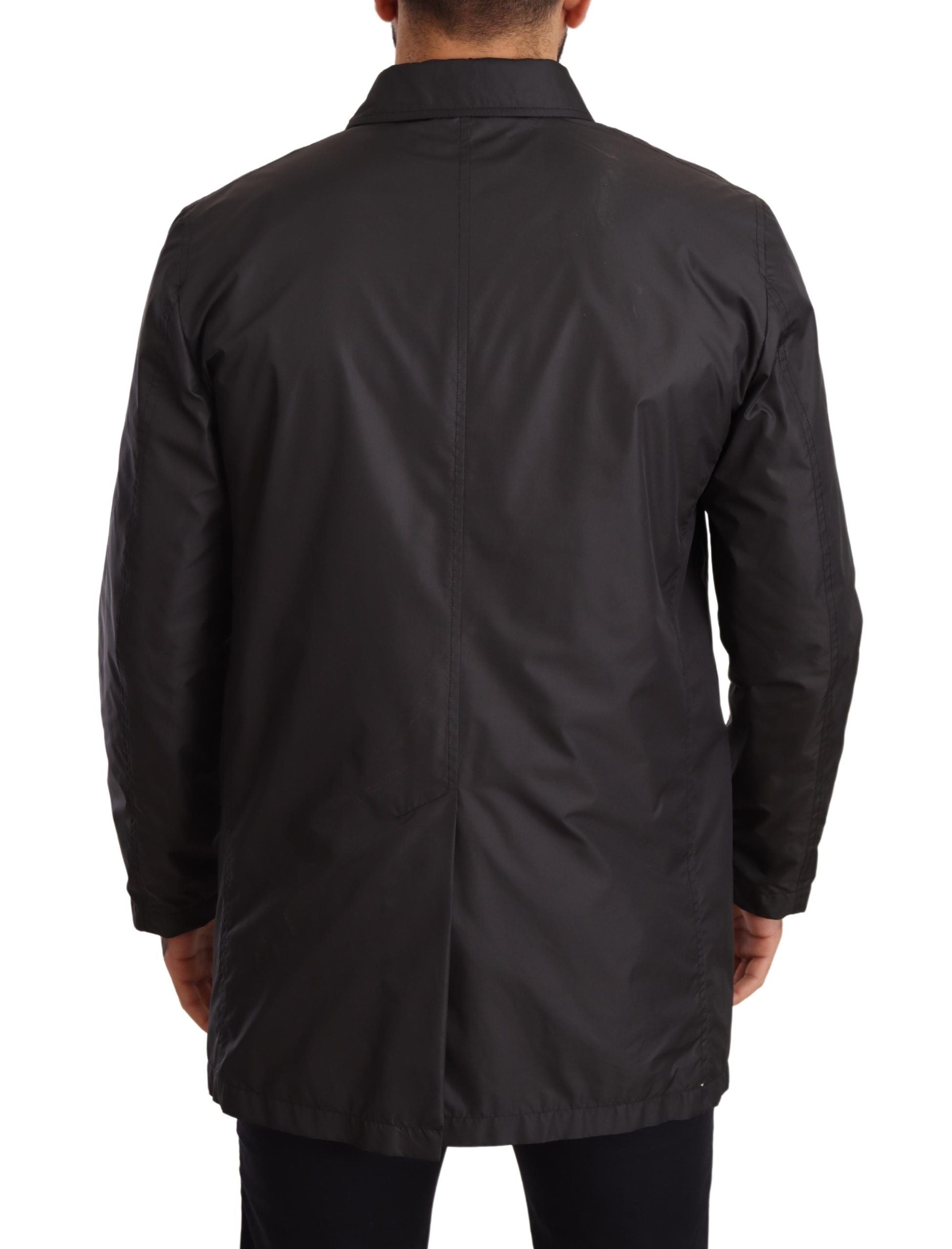 Black polyester men's trench coat jacket by Dolce & Gabbana, shown on a hanger with a classic tailored design.
