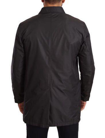Black polyester men's trench coat jacket by Dolce & Gabbana, shown on a hanger with a classic tailored design.